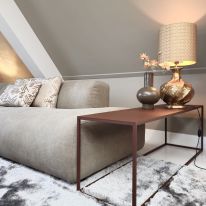 Lounge met prachtige gouden lamp en kap in reliëf.